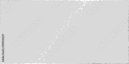 A grayscale image depicting a diagonal streak of bright spots