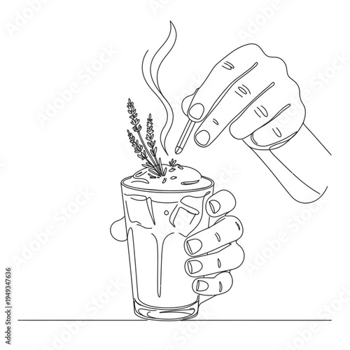 hand holding glass cup with steaming hot beverage and herbs adding sweetener