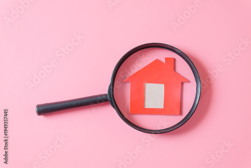 Minimal red house with magnifying glass .