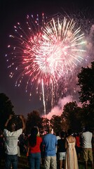 Crowd watching colorful fireworks at a Juneteenth celebration in a park, summer night festival, community gathering, Juneteenth.