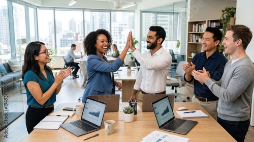 Diverse team celebrating success in modern office