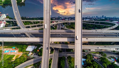 Elevated highway system with traffic, green scenery, and sunset in background