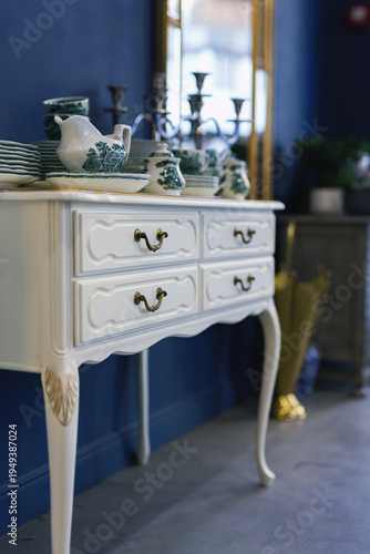 Elegant white vintage console table with porcelain tableware