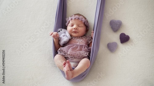 Newborn Baby Girl Posing On Swing Replica During A Photoshoot
