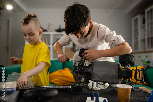 Foto Boys enjoying hobby, learning engineering skills with toy car