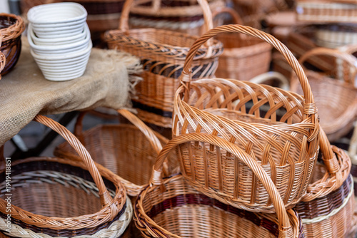 Handmade wicker baskets handles displayed outdoor craft market stall traditional weaving technique natural willow material. Rustic artisan products sale sustainable household storage picnic baskets