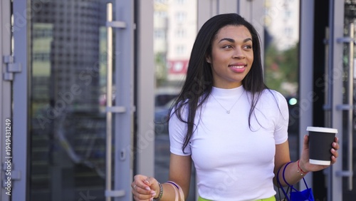 Pretty female resting outside after shopping with drink