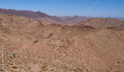 Landscape with chains of mountain ridges in the national park Saint Catherine Protectorate in Sinai’s highlands. A male tourist in a hiking trail. Active lifestyle. Vacation in Egypt.