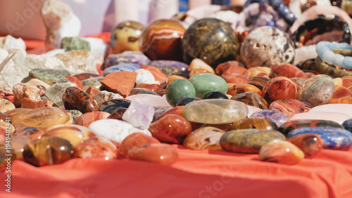 Colorful polished gemstones and minerals laying on red cloth
