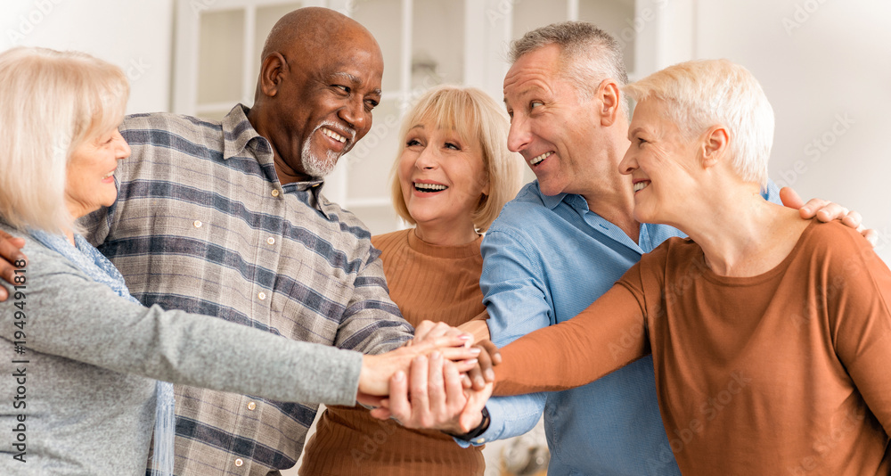 © Prostock-studio - Five adults stand close together in a home setting. They are smiling and reaching for each other's hands, showing friendship and joy. The atmosphere is warm and friendly, suggesting a good time. © Prostock-studio - Five adults stand close together in a home setting. They are smiling and reaching for each other's hands, showing friendship and joy. The atmosphere is warm and friendly, suggesting a good time.