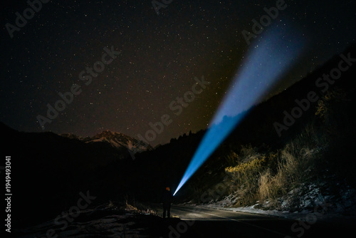 Tableau sur toile Exploration And Discovery Person With Flashlight Under Starry Night Sky In Mountains Adventure Tourism