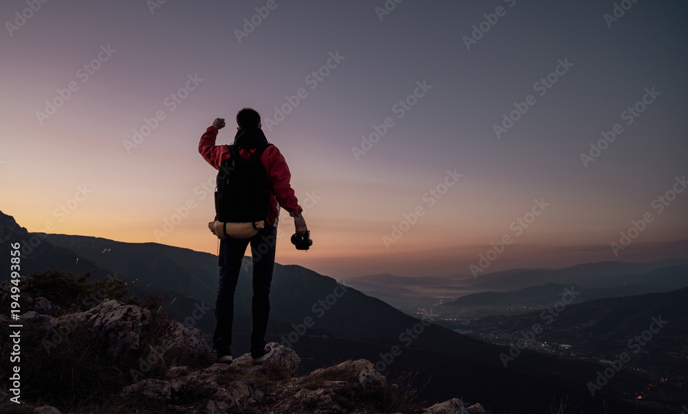 Fototapeta premium Personal Achievement And Outdoor Adventure Hiker Celebrating Success On Mountain Peak At Sunset With Backpack And Camera Reaching Goals And Overcoming Challenges