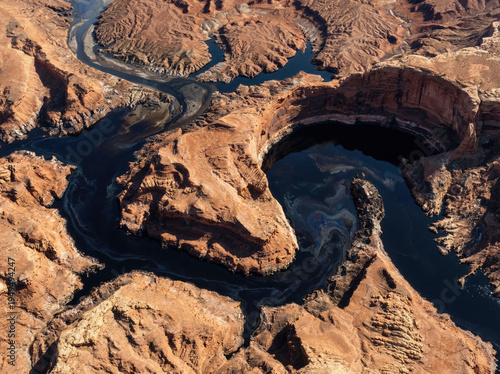 Satellite aerial view of oil river flowing through desert canyon.