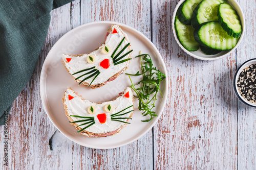 Cat sandwiches made of sausage, ricotta and whole grain bread on a plate on a table top view
