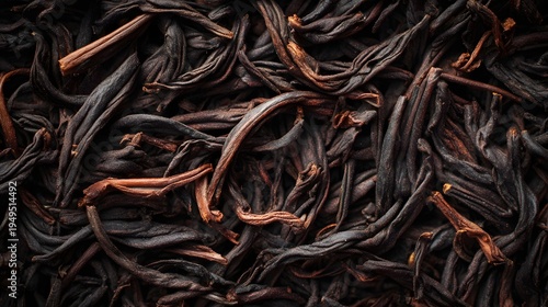 The image shows a close up view of dried, dark colored plant material, likely tea leaves or herbs