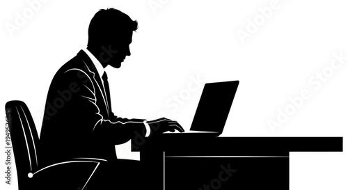 Silhouette of a businessman working on a laptop at his desk in an office