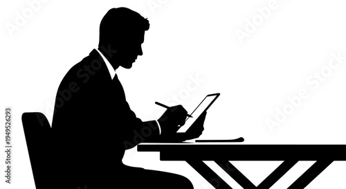 Silhouette of a businessman working on a tablet at a desk
