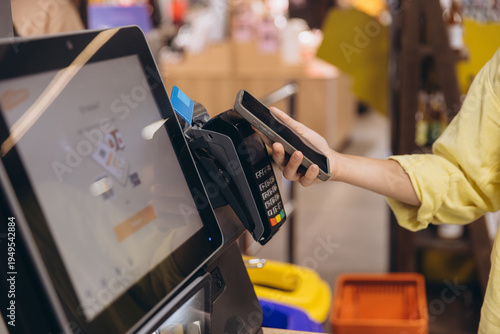 Fotografi Person making a secure contactless payment using a smartphone at a point of sale