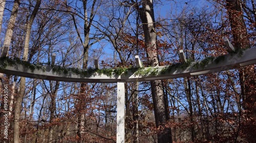 Rustic pergola with evergreen garland in autumn forest
