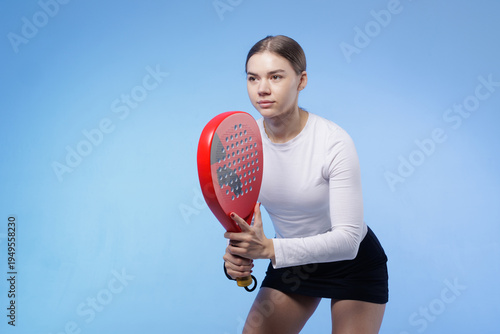 Female padel player in ready stance holding racket during sport training