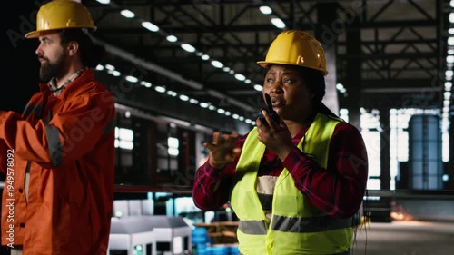 Black female engineer, walkie-talkie, production line, industry plant, two-way radio signal, portable communication in the machinery hall. Heavy industry production operations in factory.