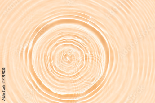 Orange water bubbles on the surface ripples. Defocus blurred transparent pink colored clear calm water surface texture with splash and bubbles. Water waves with shining pattern texture background