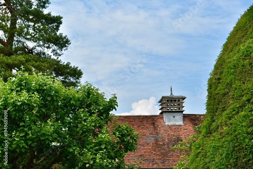 Dovecote on the red tiled roof against blue sky, West Midlands, England, UK