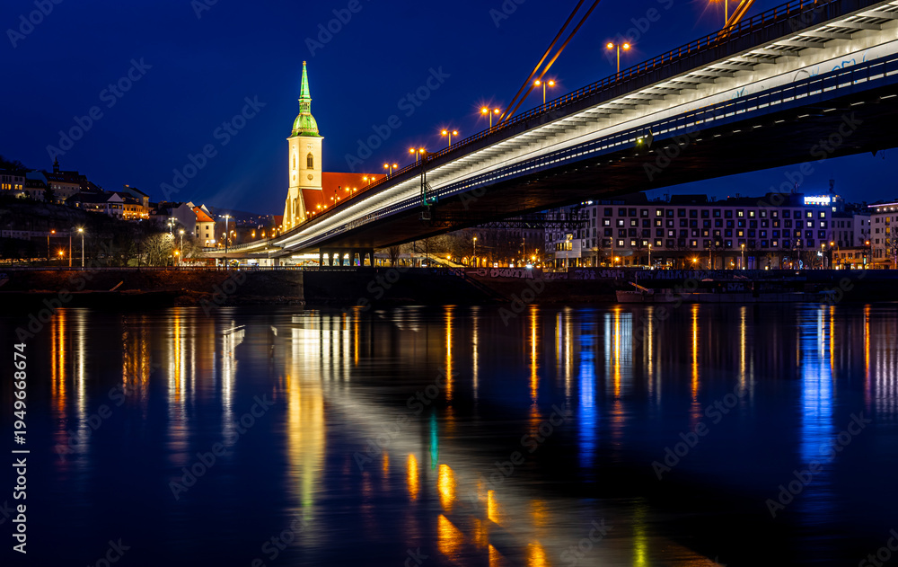 Naklejka premium Bratislava night skyline with St Martins Cathedral bridge and reflections