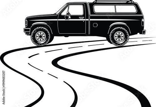 Black Pickup Truck with Camper Shell Driving on Winding Road.