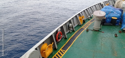 A view from the deck of a commercial vessel sailing across the vast open blue ocean water surface