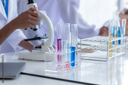 Close-up African boy and multicultural elementary students girl kids wearing lab coat uniforms using microscope with teacher in laboratory room, lifestyle pupil learning education in science class