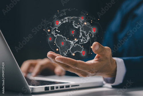 Businessman holding digital globe with location pins representing global logistics network and international business expansion. Concept of worldwide trade, supply chain, transportation