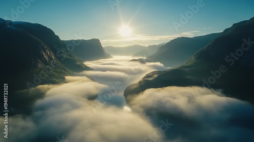 Morning mist rising over norwegian mountain valley in soft sunlight, foggy scenic nature aerial view