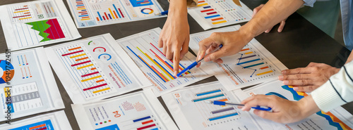 Close up of business consultant team hands pointing at data summary charts with pens on table, Corporate data analysts discussing financial strategy, market research and investment planning concept
