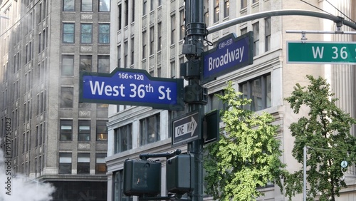 New York City Broadway and 36 street sign on Manhattan, United States. Urban road sign in american city. Traffic sign in Midtown of NYC. Building architecture, district near Herald Square. Hot steam.