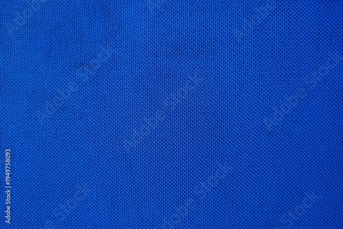 Blue textured fabric background close up with vibrant canvas weave pattern