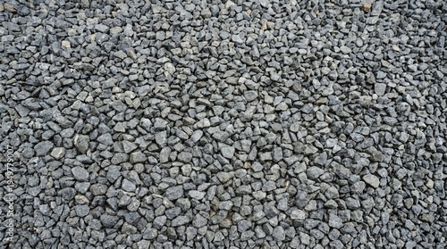 Close-up texture of a pile of dark grey gravel stones.