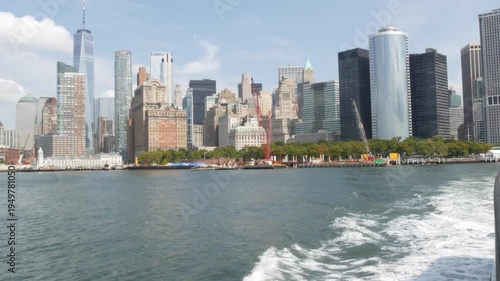 New York City Manhattan Downtown skyline from ferry boat to Liberty Island, United States. Financial District cityscape, World Trade Center skyscraper tower. Waterfront urban buildings architecture.