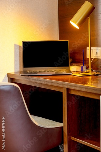 laptop on wooden desk with glowing table lamp in modern apartment workspace interior cozy home office scene with chair and computer for remote work, remote work technology interior