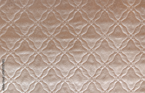 textured quilted fabric blanket surface with geometric stitched pattern in beige textile close up soft bedding material detail from modern hotel bedroom, textile production, interior design