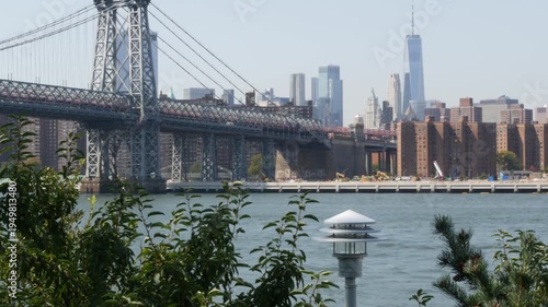 Williamsburg Bridge in Brooklyn, New York City, United States. Transport metallic bridge near Marcy Av subway station and Domino park in Williamsburg. World Trade Center skyscraper tower on Manhattan.