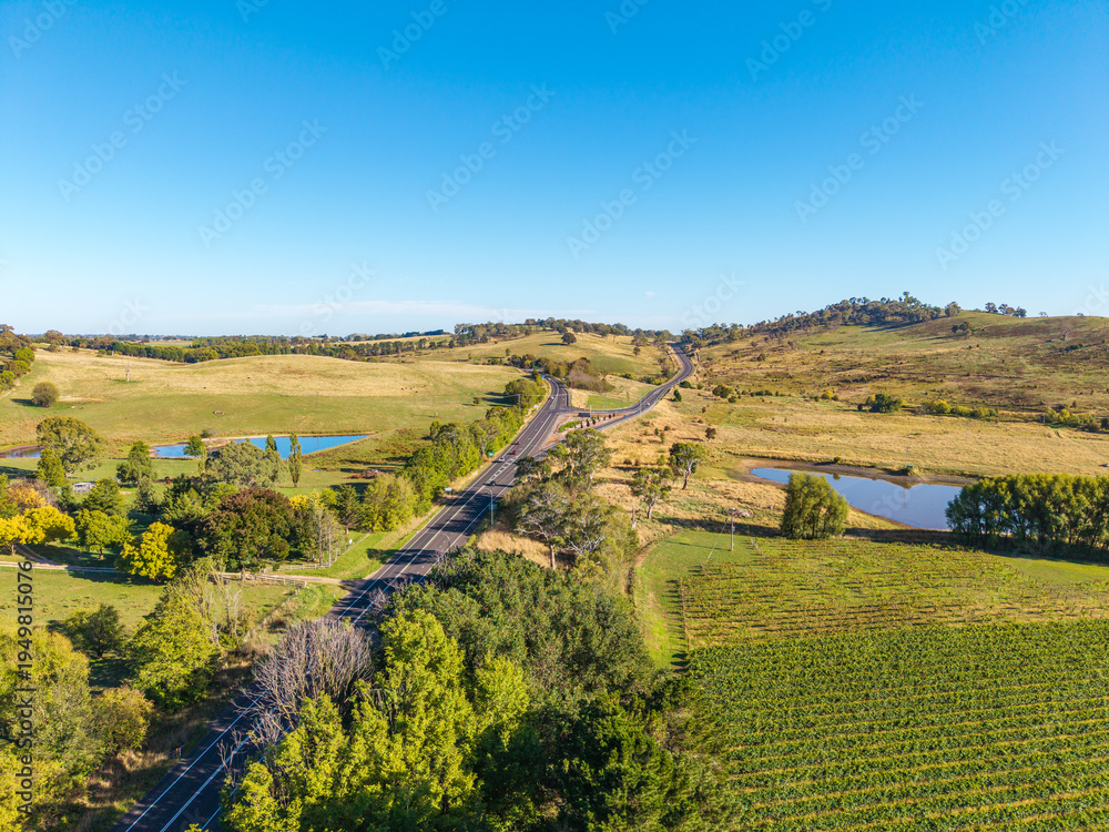 Fototapeta premium Aerial View of Mitchell Highway and Northern Distributor Road Winding Through Rural Hills and Vineyards Near Orange