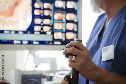Doctor looking at monitior during gastroscopy procedure, examining upper digestive tract.