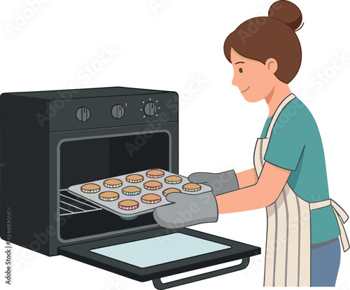 Woman taking baking tray out of oven with cookies