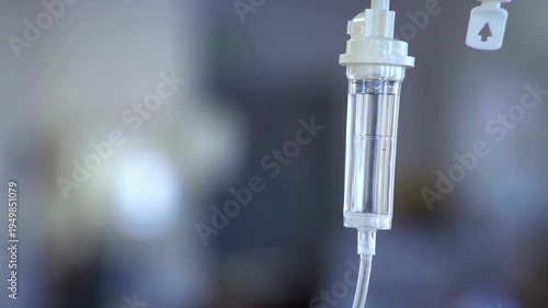 fluid intravenous saline drip in a hospital room An IV drips through the drip chamber wearing Nurse preparing IV drip in hospital Cinemagraph of a