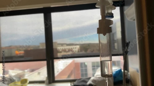 drip chamber dripping into patient A mixture of sodium chloride or salt and water Close up on Set IV fluid intravenous drop saline on a dark blue