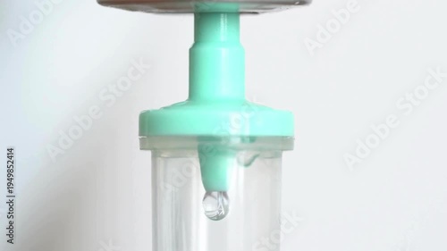 light background 4K Intravenous drip Serum drops during the surgery close up in hospital ward 0 Camera pans down an IV bottle to the IV drip below