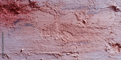 Rough old red paint texture on a weathered concrete wall surface with a dirty grunge material pattern and architectural stucco detail for a vintage backdrop