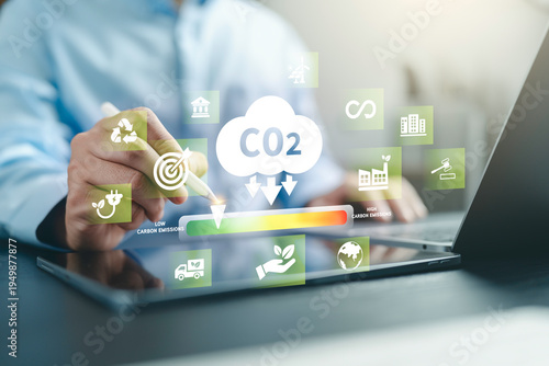 Wallpaper Mural Businessman touch Carbon emission icon on hand for Reduce levels of greenhouse gas, decarbonize industry, energy and transportation. Lower CO2 emission to limit for Carbon neutral and net zero. Torontodigital.ca