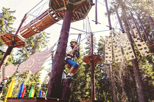 Teenage girl navigating a high ropes course in an adventure park